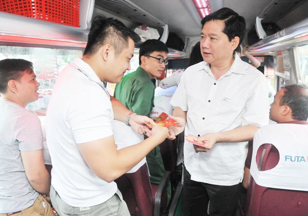 The secretary gives passengers Tet presents on a bus from Mien Tay Coach Station to Can Tho city on January 15 (Photo: SGGP)